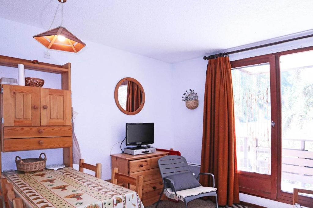 a bedroom with a bed and a tv and a window at Résidence LE POUZENC - Studio pour 6 Personnes 994 in Les Orres