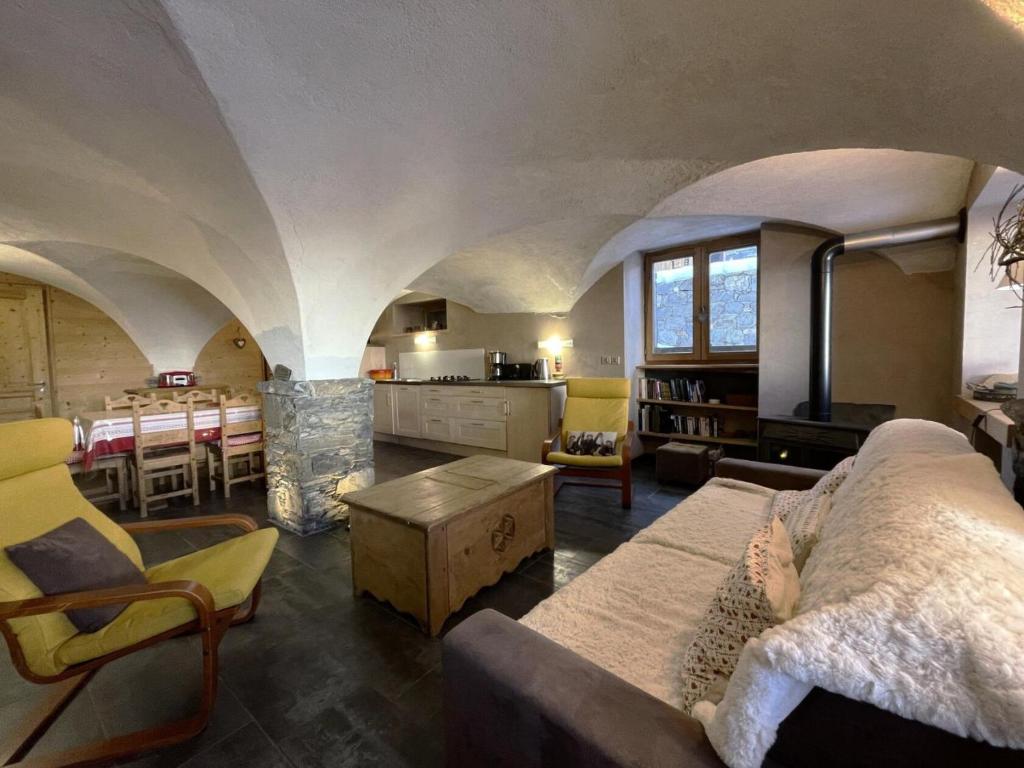 un grand salon avec un canapé et une table dans l'établissement Résidence La Croix De Fer - Appartement vouté rénové à St Martin de Belleville MAE-4994, à Saint-Martin-de-Belleville