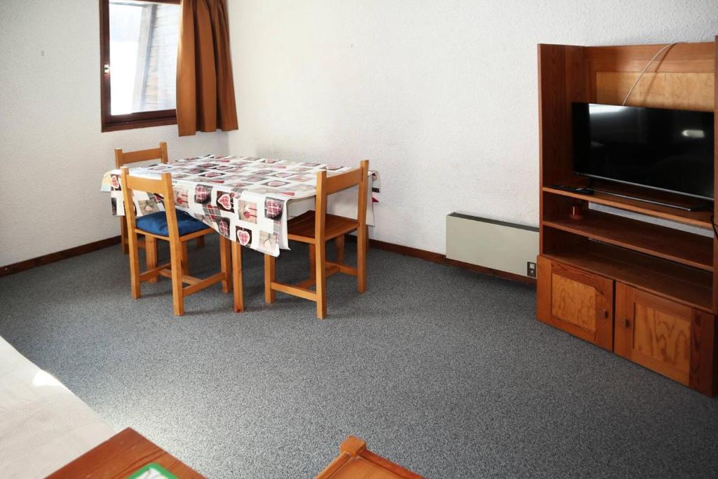 une pièce avec une table, des chaises et une télévision dans l'établissement Résidence Pic Vert - départ skis aux pieds MAE-8494, aux Orres