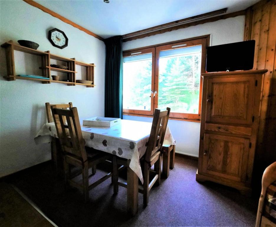une salle à manger avec une table et des chaises et une fenêtre dans l'établissement Résidence Gentianesmen - Studio 4 personnes aux Ménuires MAE-5334, aux Menuires