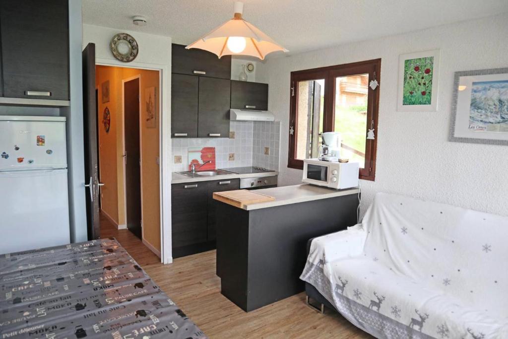 a kitchen with a sink and a counter with a microwave at Résidence Les 7 Berge - Studio pour 5 Personnes 614 in Les Orres