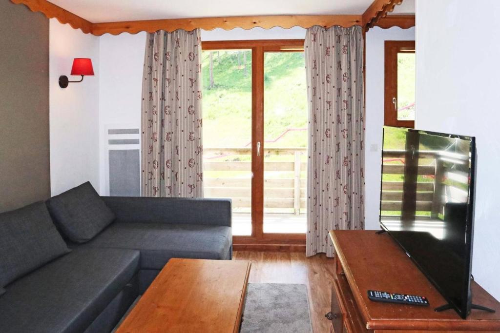 un salon avec un canapé et une télévision à écran plat dans l'établissement Résidence Les Colchiques - 2 Pièces pour 6 Personnes 604, aux Orres