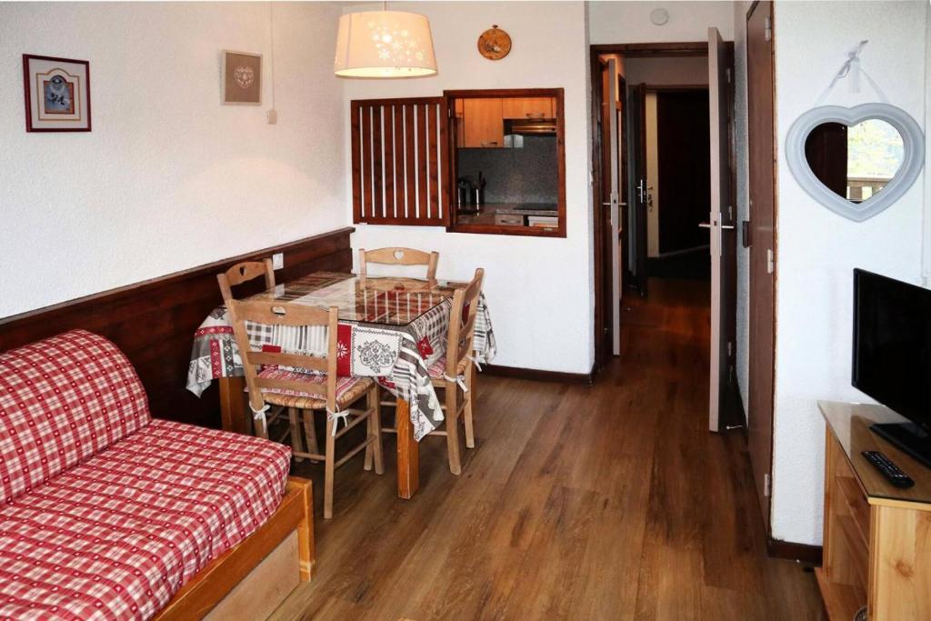 un salon avec un canapé et une table avec des chaises dans l'établissement Résidence Le Belvedere - GRAND STUDIO 5 PERSONNES CENTRE STATION MAE-6634, aux Orres