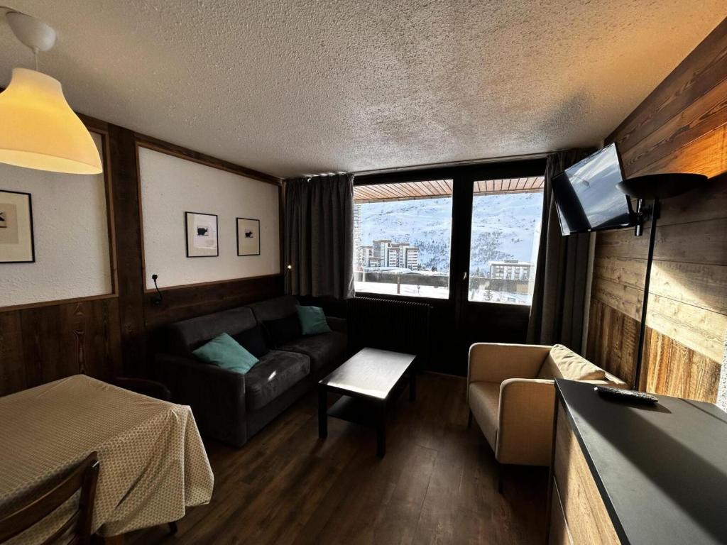 un salon avec un canapé et une table dans l'établissement Résidence Aravis - Appartement 6 pers ski au pied à la Croisette MAE-5444, aux Menuires