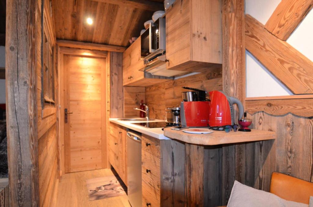 eine Küche in einem Blockhaus mit einer Arbeitsplatte in der Unterkunft Résidence Necou - Studio pour 3 Personnes 954 in Les Menuires