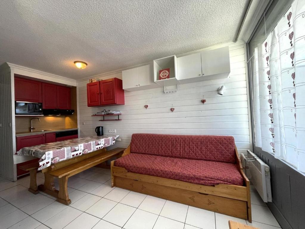 a room with a bench in a kitchen with red cabinets at Résidence Villaret - Grand studio 4 personnes aux Menuires - accès 3 Vallées MAE-5734 in Les Menuires