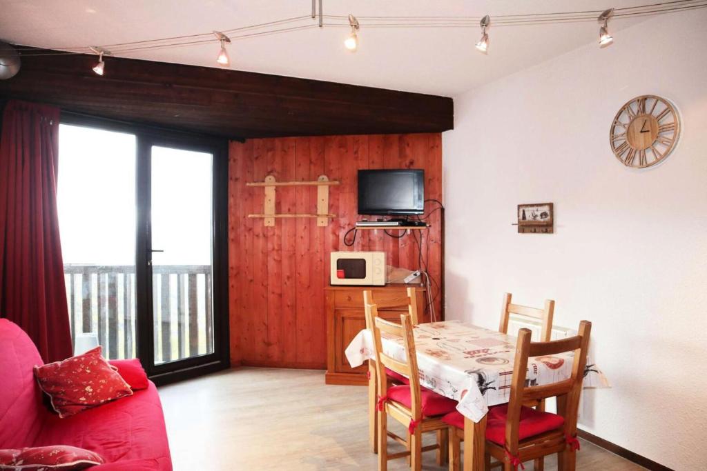 a living room with a dining room table and a tv at Résidence Les Carlines - Studio pour 4 Personnes 274 in Le Mélézet