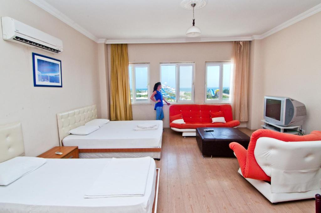 a room with two beds and a living room at Prestij Apart Hotel in Lara