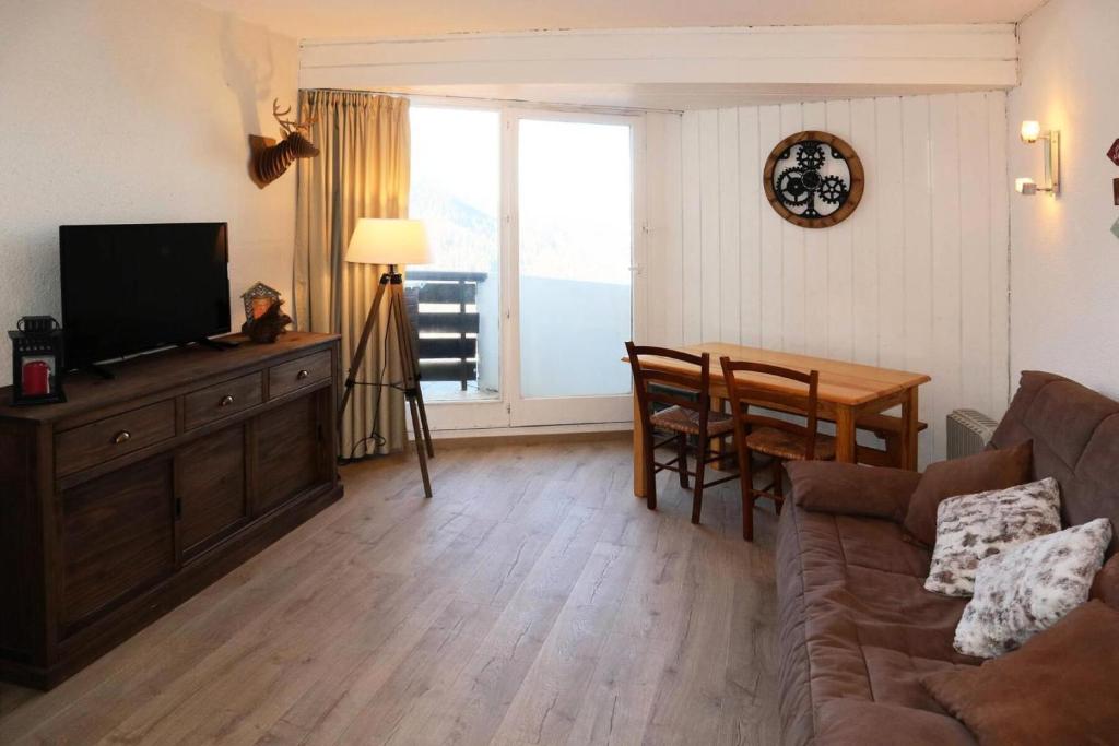 un salon avec un canapé, une télévision et une table dans l'établissement Résidence Les Carlines - Studio équipé pour 4 personnes au coeur de station MAE-3264, aux Orres