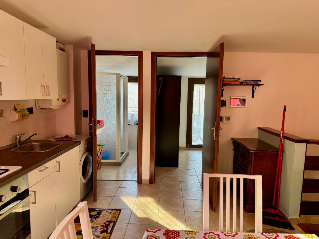 una cocina con fregadero y una puerta a una habitación en VIDI HOME, en Vidiciatico