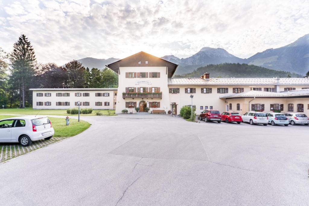 a large building with cars parked in a parking lot at BSW Hotel Hubertus-Park in Schönau am Königssee