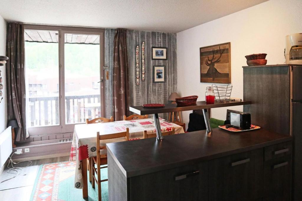 Il comprend un salon avec une cuisine dotée d'une table et d'une fenêtre. dans l'établissement Résidence Les Carlines - 707 LES CARLINES 1650 MAE-2294, à Le Mélézet