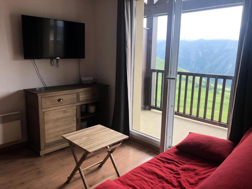 un salon avec un canapé et une télévision et un balcon dans l'établissement Résidence Hameau De Balestas Mp - T2/6pers FORUM 21- Peyresourde MAE-4674, à Germ