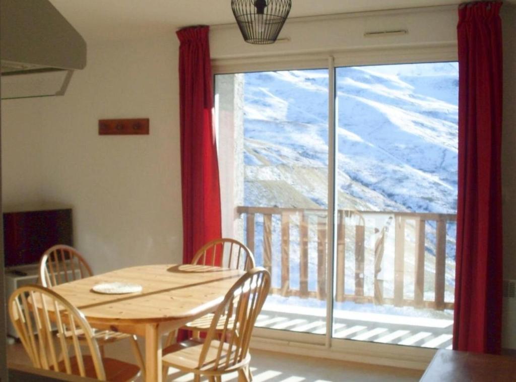 a table and chairs in a room with a large window at Résidence Royal Peyragudes Mp - Studio pour 4 Personnes 994 in Germ