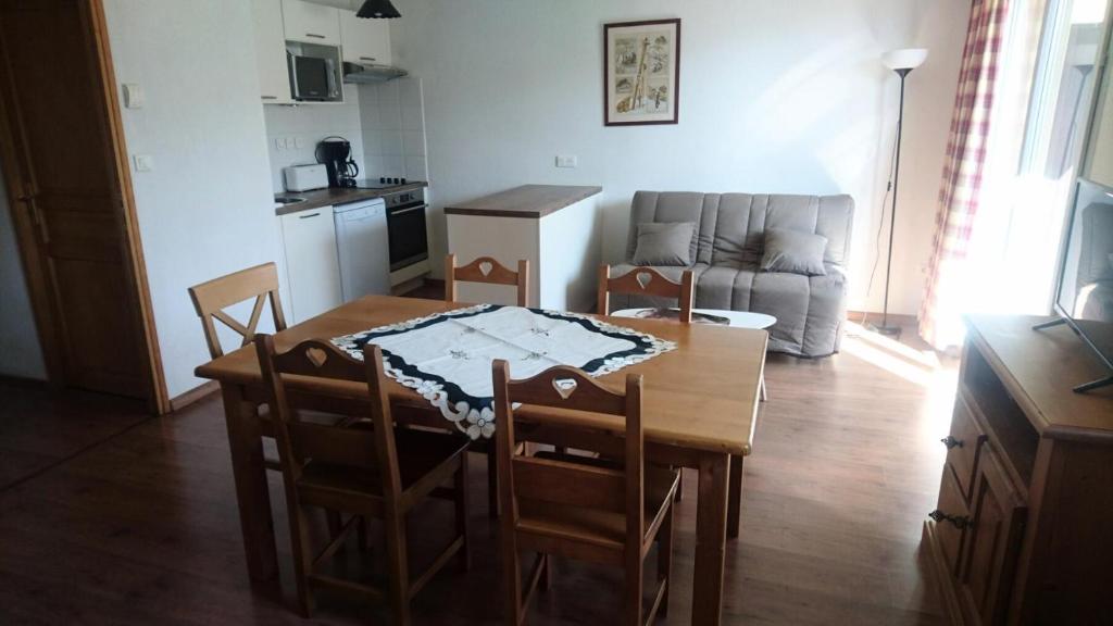 un salon avec une table et des chaises et une cuisine dans l'établissement Résidence Hameau De Balestas Mp - T3/6pers FORUM 26- Peyresourde MAE-4694, à Germ