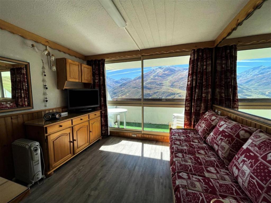 un salon avec un canapé et une grande fenêtre dans l'établissement Résidence Tougnette - Appartement pour 4 personnes avec balcon exposé Sud MAE-6864, aux Menuires