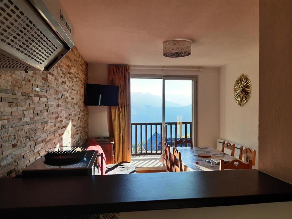 d'un salon avec une table et une vue sur un balcon. dans l'établissement Résidence Hameau De Balestas Mp - T2/6pers FORUM 18- Peyresourde MAE-4684, à Germ