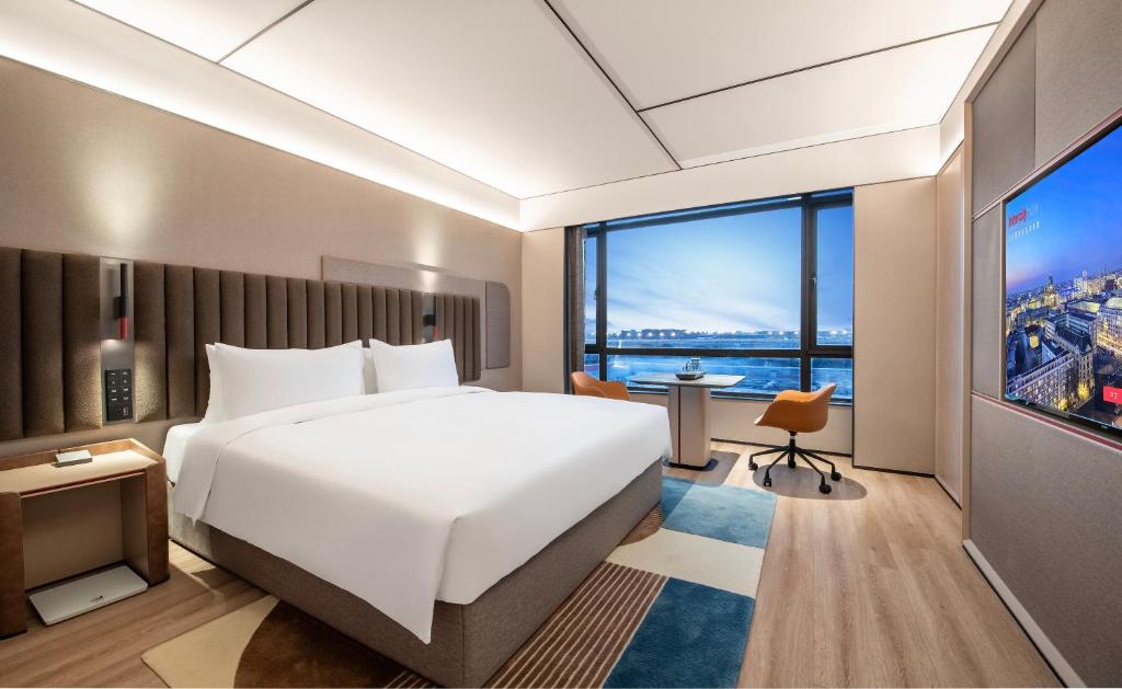 a hotel room with a large bed and a large window at IntercityHotel Shanghai Hongqiao Airport - Free Minibar for First Night in Shanghai