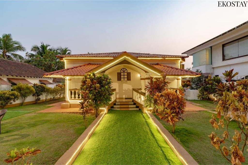 a house with a lawn in front of it at EKOSTAY Gold - CASA PORTO Villa in Anjuna