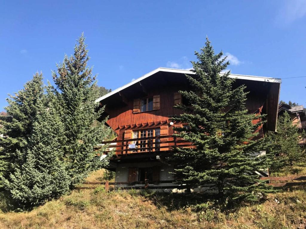 une grande maison en bois sur une colline avec des arbres dans l'établissement Chalet Chamois - Chalet année 70 ! Quartier calme - Superbe vue - Jardin MAE-8214, à Montgenèvre