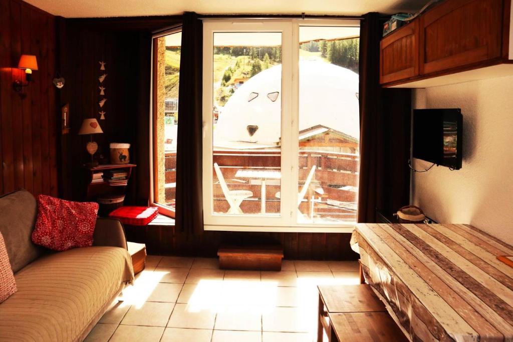 un salon avec un canapé et une grande fenêtre dans l'établissement Résidence Les Carlines - Joli studio de 4 personnes en cœur de station vue pistes MAE-3714, à Le Mélézet