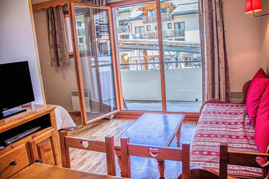 un salon avec un canapé et une grande fenêtre dans l'établissement Résidence Les Eglantines - 2 pièces 6 personnes place centrale les Orres 1800 MAE-4824, aux Orres