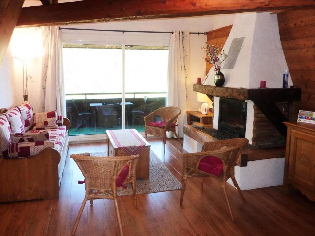 - un salon avec une cheminée, une table et des chaises dans l'établissement Résidence Les Anemones - Très grand appartement 8 personnes MAE-3684, à Le Mélézet