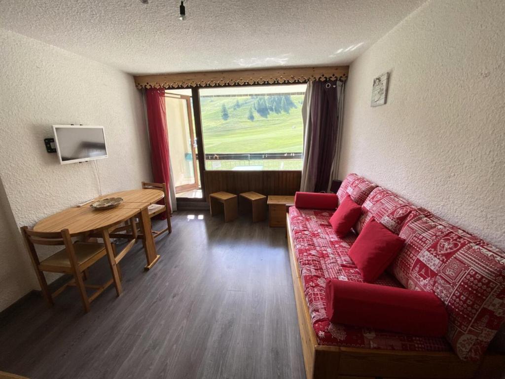 un salon avec un canapé rouge et une table dans l'établissement Résidence Chalmettes - Studio 2/4 personnes - SKIS AUX PIEDS MAE-8994, à Montgenèvre
