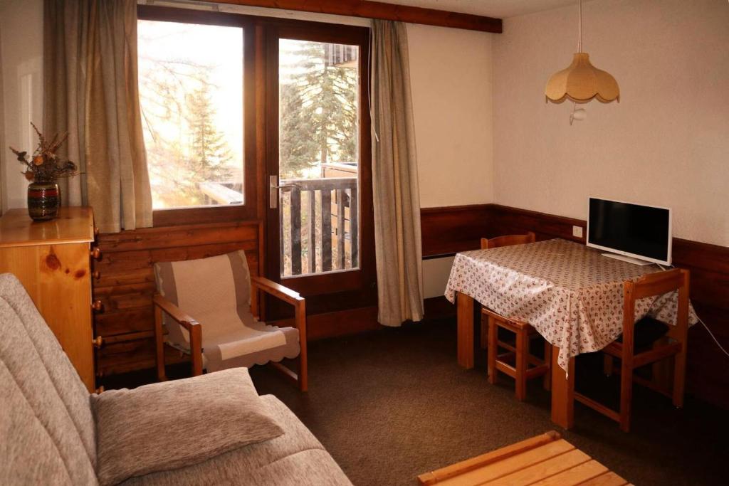 un salon avec une table avec un ordinateur portable dessus dans l'établissement Résidence Le Belvedere - Mini studio 2 personnes MAE-7014, aux Orres