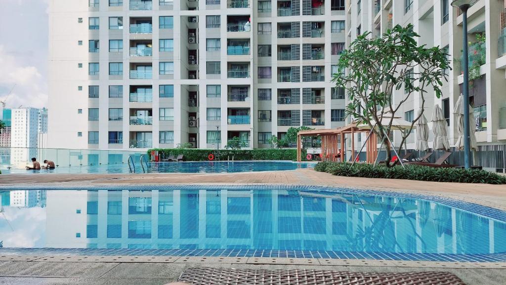 a swimming pool in front of a tall building at Suite Living Furnished Suites - Saigon City Center 2 Bedroom & 3 Bedroom in Ho Chi Minh City