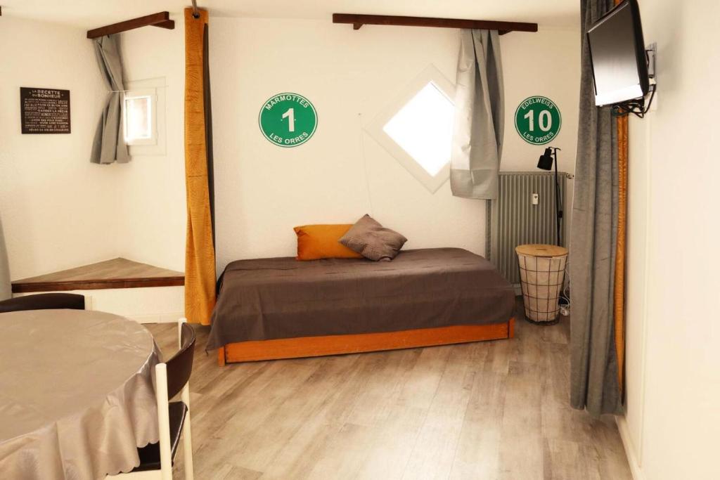 - une chambre avec un lit dans une pièce avec des panneaux verts dans l'établissement Résidence Le Boussolenc - Studio équipé pour 4 personnes MAE-4144, aux Orres
