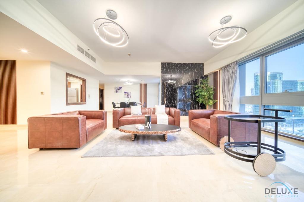 uma sala de estar com um sofá e uma mesa em Spacious 3BR with Assistant’s Room at West Heights 4 Business Bay by Deluxe Holiday Homes no Dubai