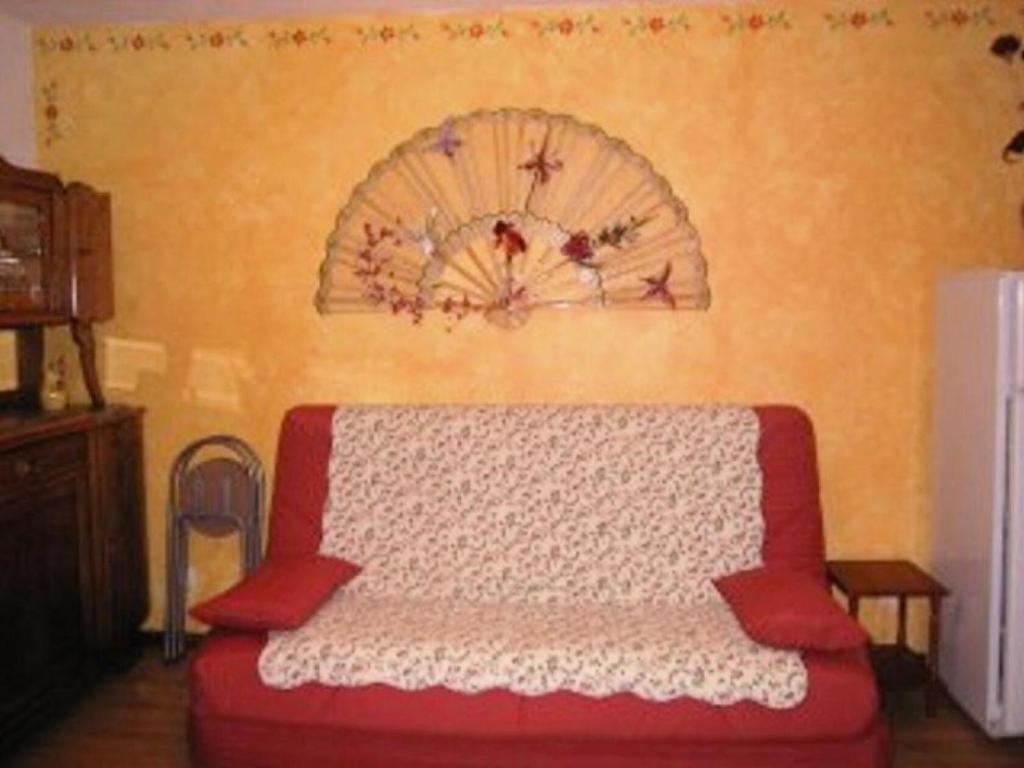 - un canapé rouge dans une chambre avec un mur dans l'établissement Résidence Orr Des Cimes - STUDIO 4 PERSONNES CENTRE STATION MAE-3841, aux Orres