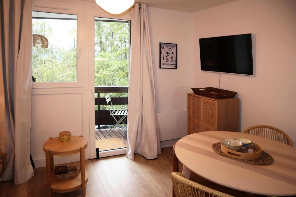 un salon avec une table et une grande fenêtre dans l'établissement Résidence Aupillon - LES ORRES 1650 APPARTEMENT 4 PERSONNES MAE-4134, aux Orres