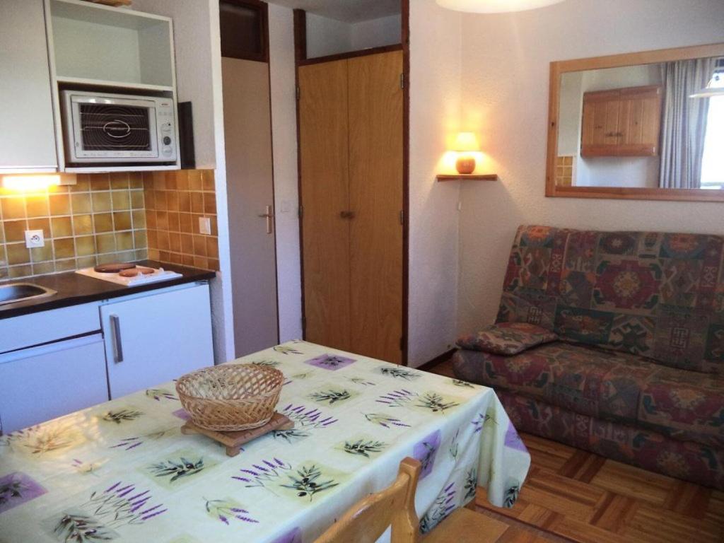 a kitchen and a table with a basket on top of it at Résidence Le Meale - Studio pour 4 Personnes 891 in Les Orres