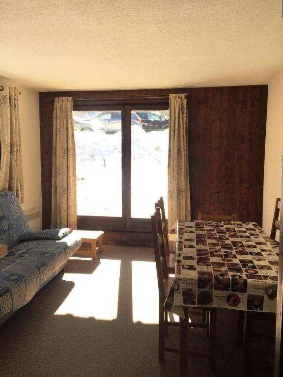- un salon avec une table, un canapé et une fenêtre dans l'établissement Résidence Le Pic Vert - LE PIC VERT - 2 pièces pour 6 personnes MAE-3931, aux Orres