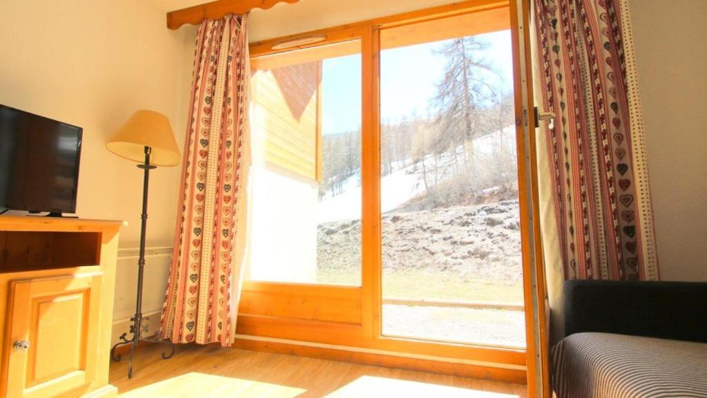 d'un salon avec une porte coulissante en verre et une fenêtre. dans l'établissement Résidence Parc Aux Etoiles - CH28PAE - CHALET TRIPLEX T5 - TERRASSE - 7 PERS MAE-2104, à Narreyroux