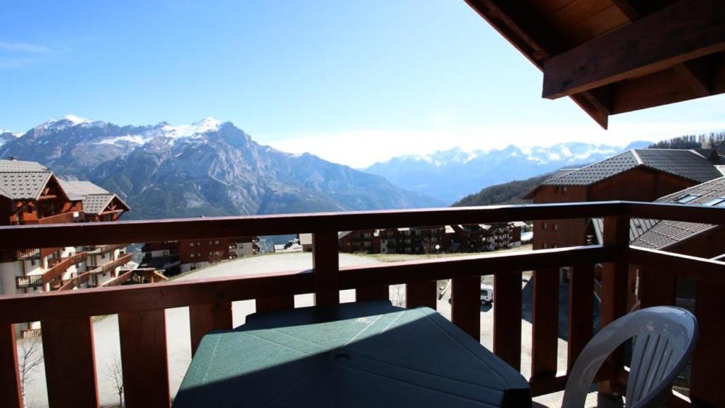 un balcon avec une table et une vue sur les montagnes dans l'établissement Résidence Parc Aux Etoiles - A204PAE - APPARTEMENT 1 CHAMBRE, BALCON MAE-2324, à Narreyroux