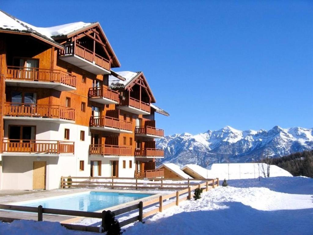 un bâtiment avec une piscine dans la neige dans l'établissement Résidence Parc Aux Etoiles - C411PAE - APPARTEMENT 1 CHAMBRE, BALCON MAE-2574, à Narreyroux