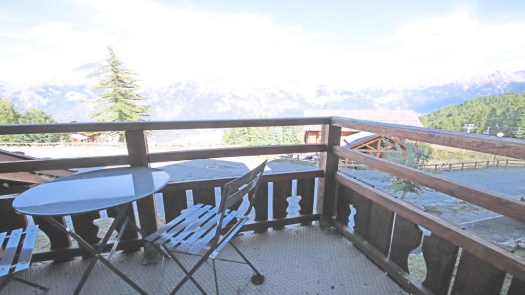 une table et des chaises sur un balcon avec vue sur une montagne dans l'établissement Résidence Dame Blanche - DBA112 - APPT 1 CHAMBRE + CABINE - BALCON - 6 PERSONNES MAE-2824, à Narreyroux