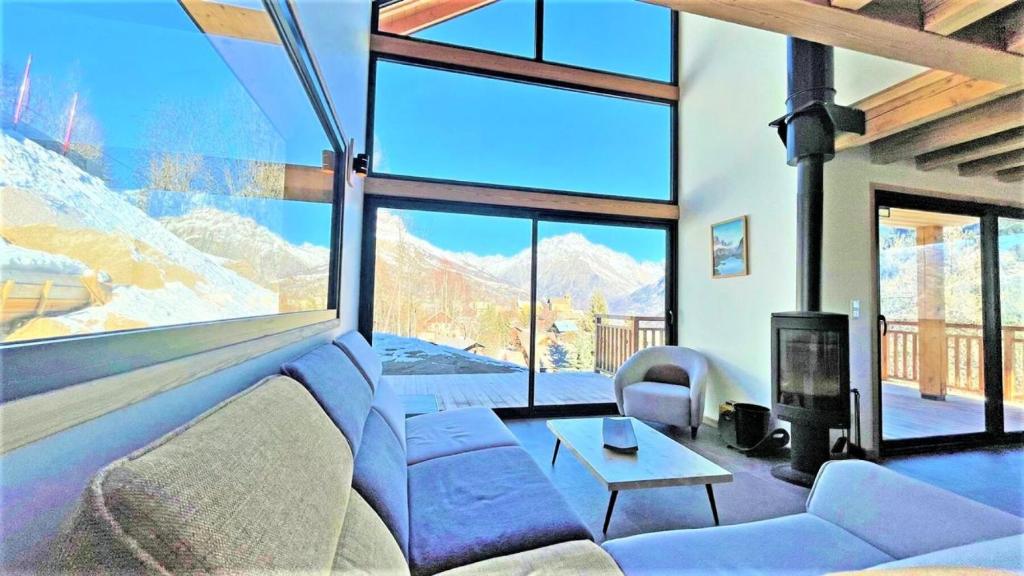 a living room with a couch and a large window at Chalet - Chalets pour 12 Personnes 644 in Les Prés