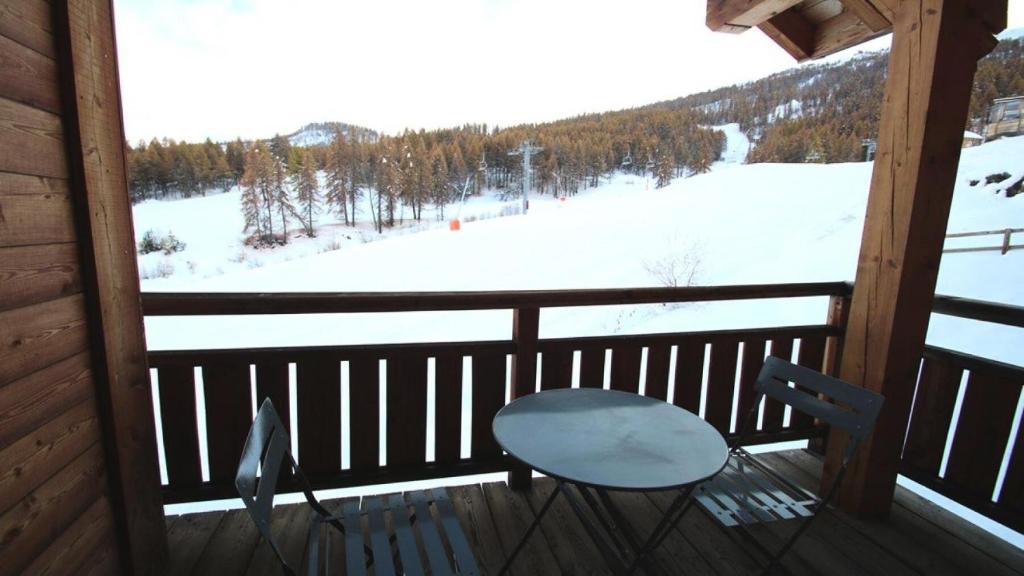 une chaise sur une terrasse couverte avec vue sur un champ enneigé dans l'établissement Résidence Dame Blanche - DBAC16 - APPT 2 CHAMBRES - BALCON - 6 PERSONNES - Secteur 1800 MAE-2654, à Narreyroux