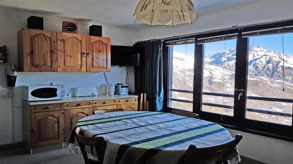 Il comprend une cuisine dotée d'une grande fenêtre offrant une vue sur la montagne. dans l'établissement Résidence Pendine 1 - P802 - Grand studio/Alcove - 5 personnes - Centre de station MAE-2664, à Les Prés