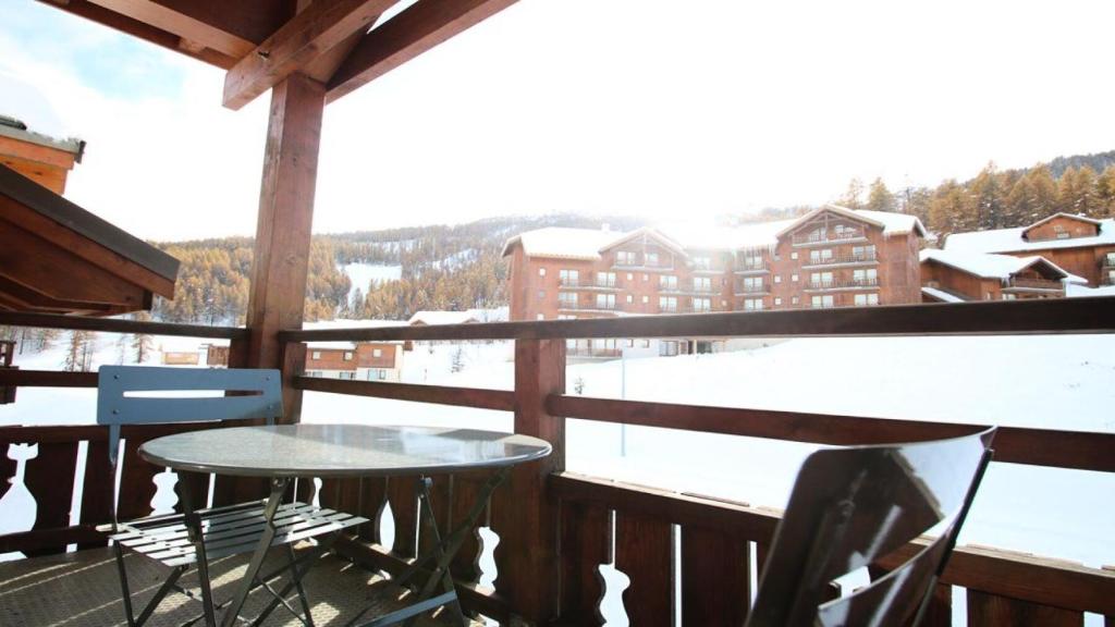 - une table et des chaises sur le balcon d'un lodge de ski dans l'établissement Résidence Dame Blanche - DBA417 - APPT 2 CHAMBRES + COIN MONTAGNE - BALCON - 8 PERSONNES MAE-7564, à Narreyroux