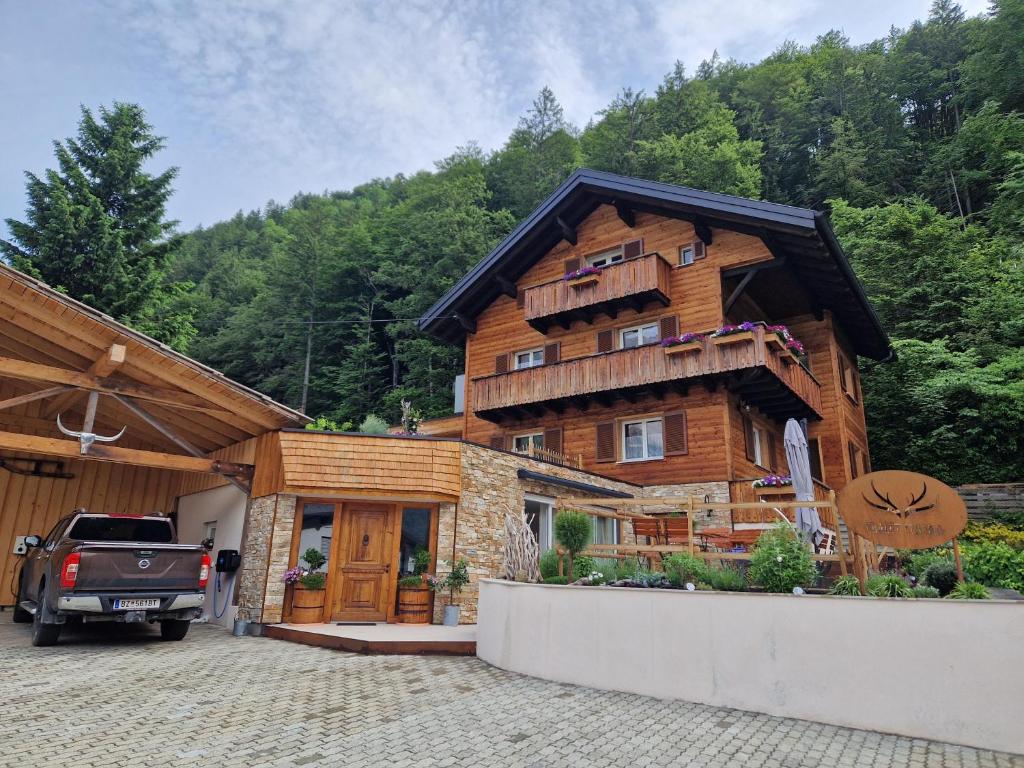 ein großes Holzhaus mit einem davor geparkt in der Unterkunft Chalet Claudia in Bartholomäberg