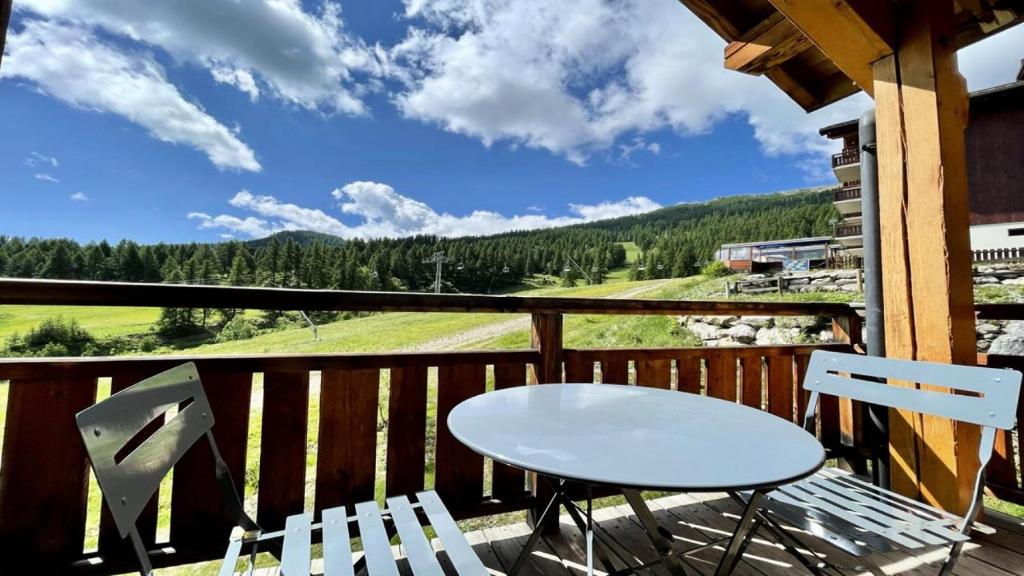 une table et deux chaises sur un balcon avec vue dans l'établissement Résidence Dame Blanche - DBAC24 - APPT DUPLEX DANS CHALET - 4 CHAMBRES 10 PERSONNES - Secteur 1800 MAE-7984, à Narreyroux