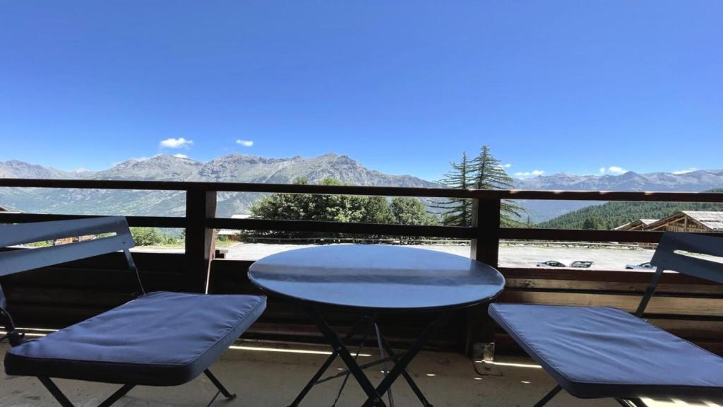 a table and two chairs on a balcony with mountains at Résidence Dame Blanche - 3 Pièces pour 8 Personnes 014 in Narreyroux