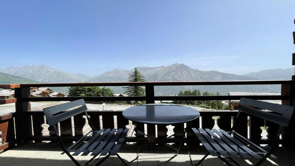 a table and chairs on a balcony with a view of mountains at Résidence Dame Blanche - 2 Pièces pour 6 Personnes 074 in Narreyroux