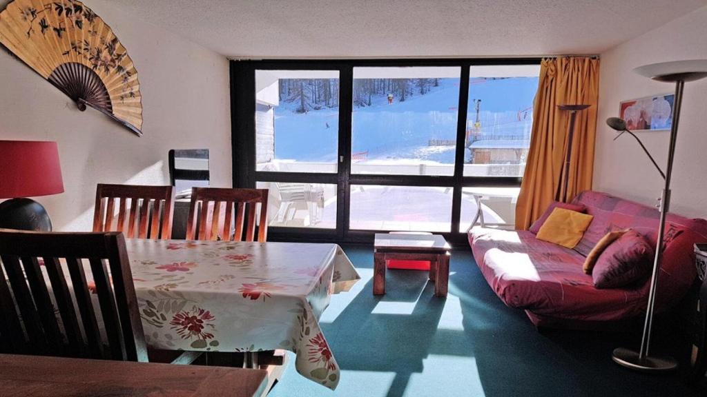 uma sala de estar com uma mesa e um sofá em Résidence Cortina 1 - Appartements pour 4 Personnes 914 em Les Prés