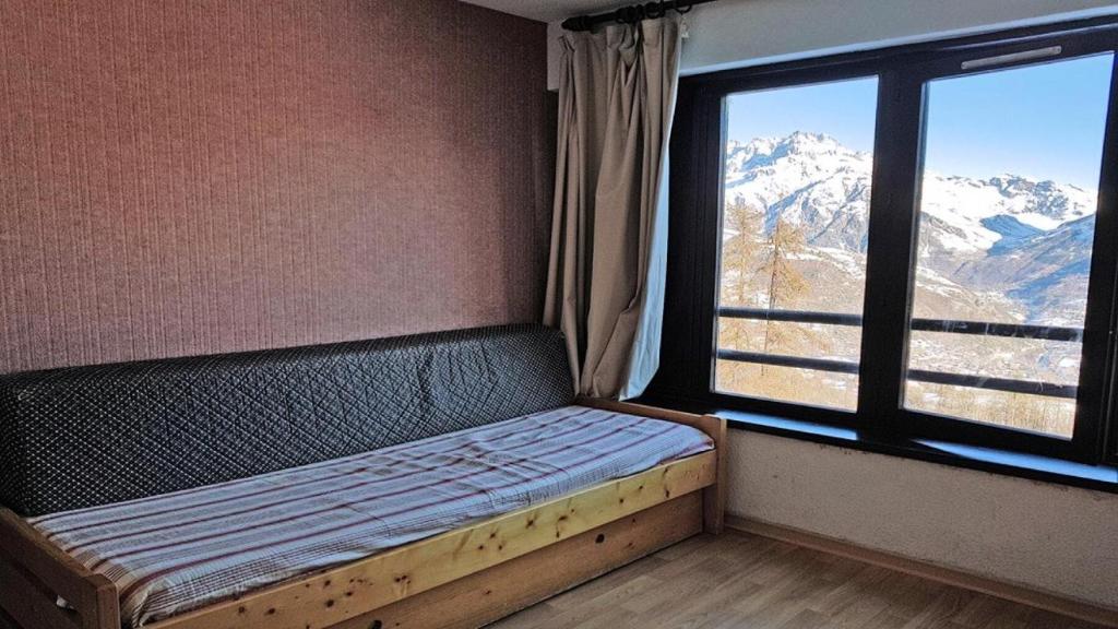 un lit dans une chambre avec une grande fenêtre dans l'établissement Résidence Pendine 1 - P404 - APPARTEMENT 3/4 PERSONNES EN CENTRE STATION MAE-8554, à Les Prés